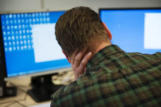 Oudere man die over zijn nek wrijft