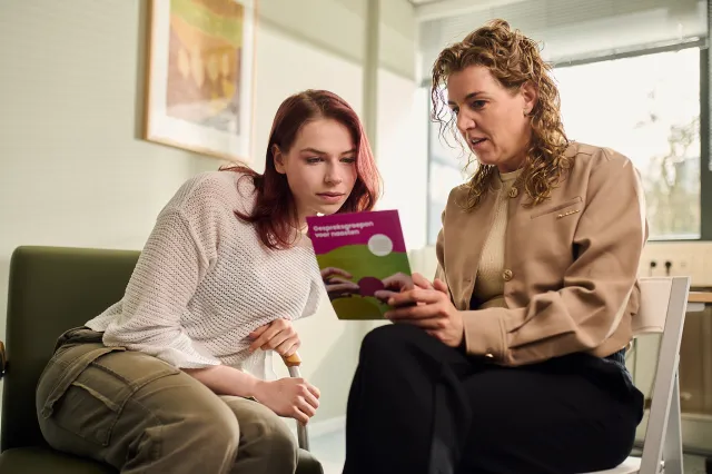 Close-up folder uitleg jongere behandelaar